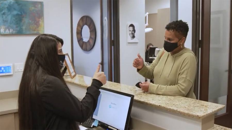Dental team member giving thumbs up to dental patient