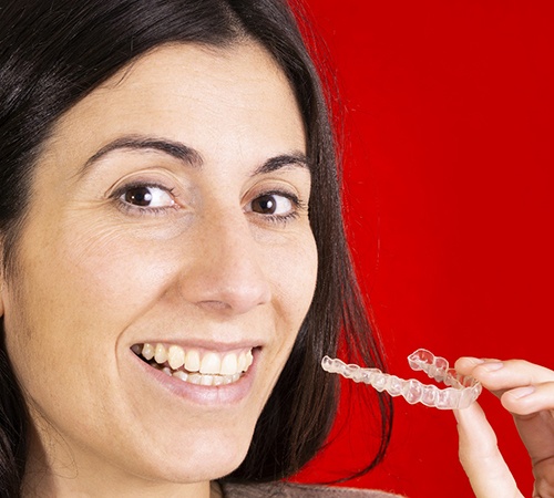 Woman holding clear aligner