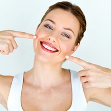 Smiling woman pointing to her mouth