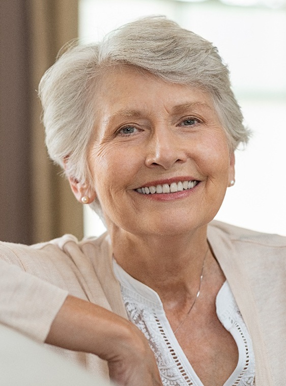 smiling woman with implant dentures in Houston, TX
