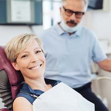 Older woman smiling while visiting an implant dentist in Houston