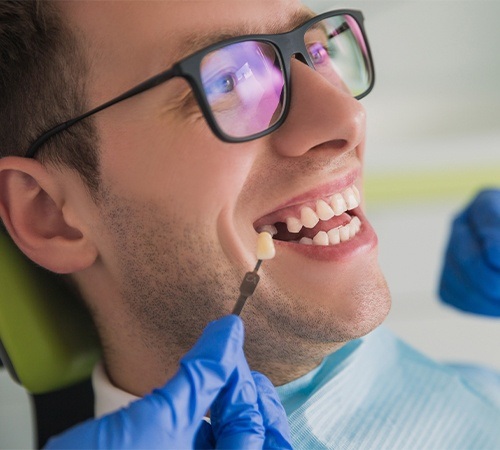 Man with missing tooth looking at replacement tooth color options