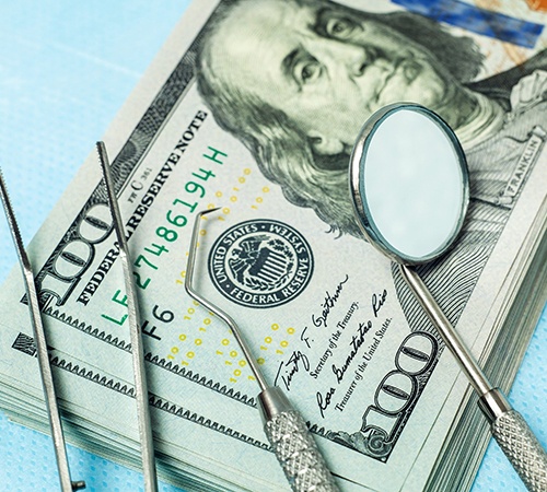 Dental instruments on stack of cash