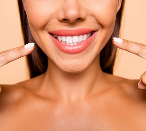 woman pointing at her smile