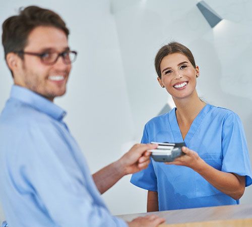 A patient paying the cost of veneers in Houston